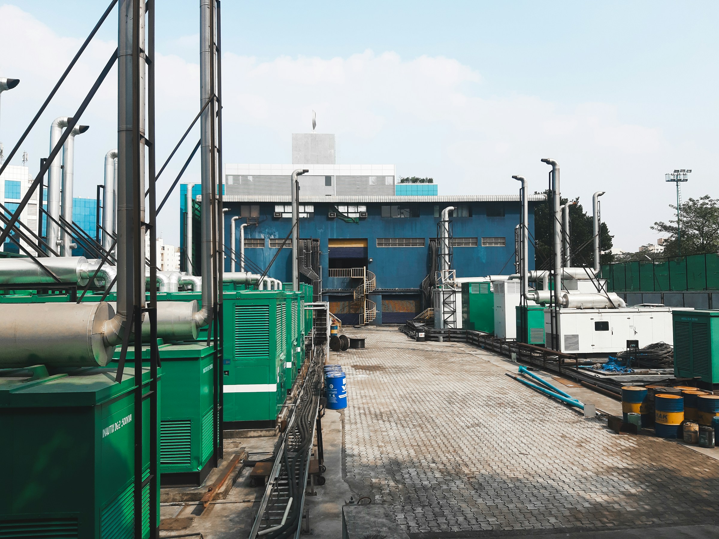 Enclosed generator sets and exhaust stacks at an industrial facility