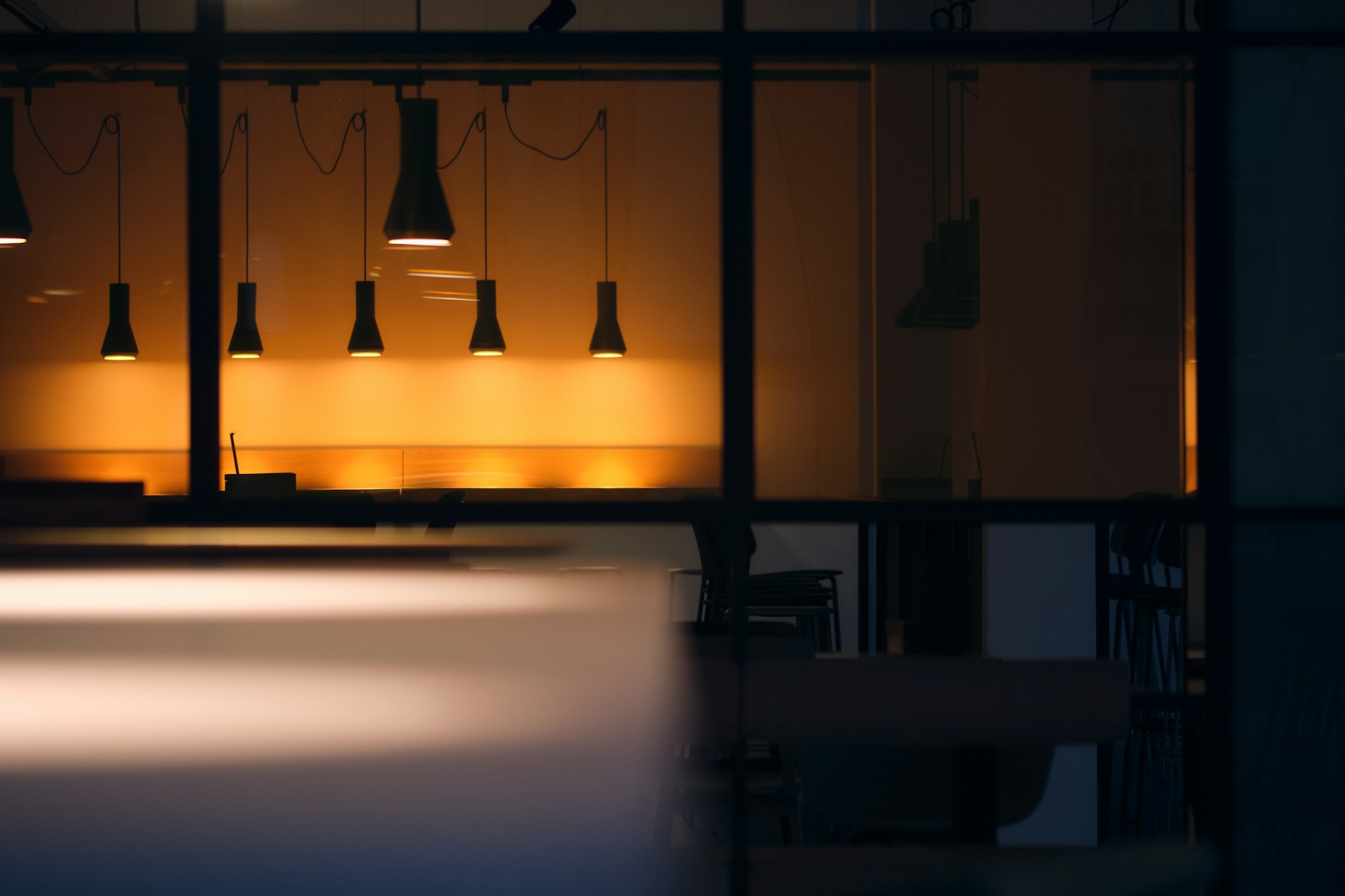 Rows of pendant fixtures casting warm light in a modern commercial interior