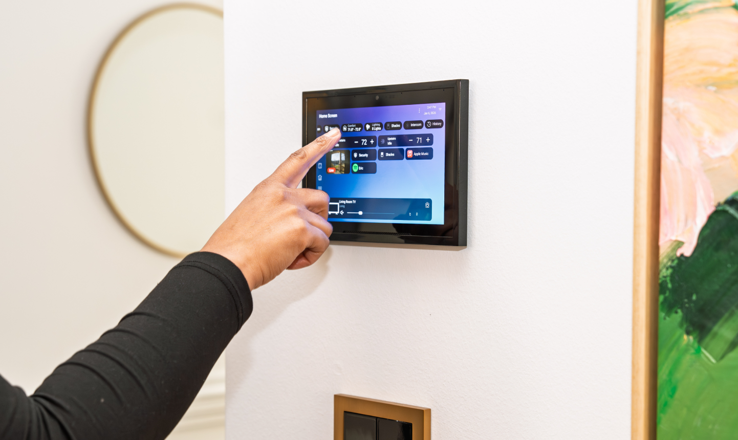 A person using an official Control4 T5 wall-mounted touchscreen in a home