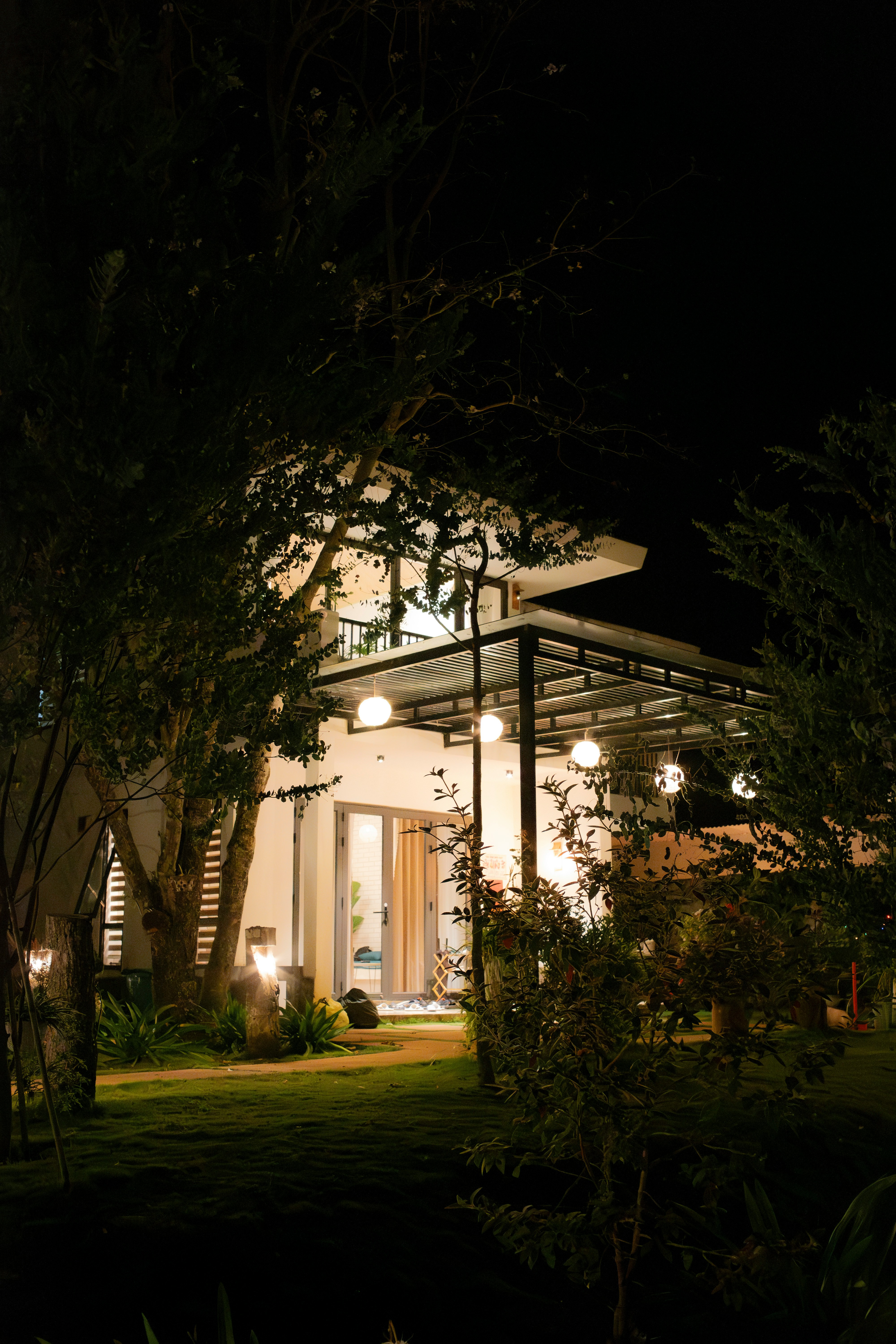 Warm porch and garden lighting outside a home at night